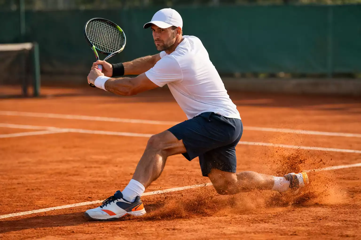 Joueur de tennis en position de revers sur terre battue